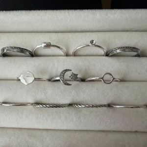 Set med silverringar - Ett set med stilrena silverringar i olika designer. Inkluderar ringar med måne och stjärna, samt en med en liten sten. Perfekt för att mixa och matcha. 13st. Aldrig använt 