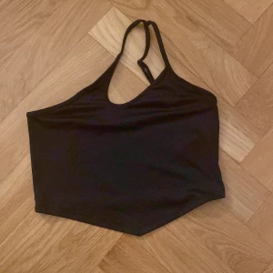 Svart oneshoulder topp från FB Sister - Snygg svart oneshoulder topp från FB Sister i en stilren design. Perfekt för en trendig look med sin asymmetriska axelrem. Tillverkad i ett mjukt och bekvämt material.