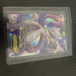 Mewtwo EX Pokémonkort - Säljer ett Mewtwo EX Pokémonkort med holografisk effekt. Kortet har nummer 52/99 och visar Mewtwo i en kraftfull pose. Perfekt för samlare eller Pokémon-entusiaster!