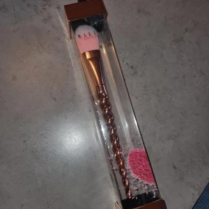 Sminkborste  - Snygg sminkborste med rosa borst och ett unikt spiralformat handtag i roséguld. 