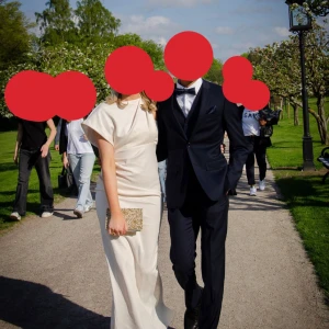 Champagnefärgad klänning från ASOS DESIGN - Elegant champagnefärgad klänning från ASOS DESIGN med en stilren och sofistikerad look. Klänningen har en draperad halslinje och är ärmlös, vilket ger en chic och modern känsla. Perfekt för speciella tillfällen.Skriv för fler bilder!!!  Säljer min super fina och jätte sköna balklänning.  Storlek 40/m. Den är bandeau och sen ett tyg över som gör den till one shoulder. 💖💖