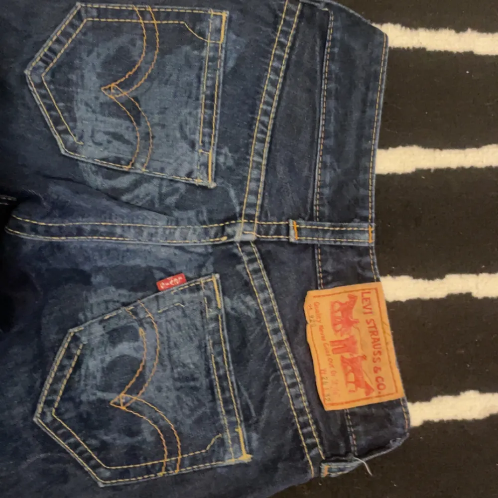 Säljer ett par klassiska blå jeans från Levi's med snygga kontrastsömmar och femficksdesign. De har en normal passform och är perfekta för en avslappnad stil. Levi's logotyp syns tydligt på bakfickan. Waist 26. . Farkut & Housut.