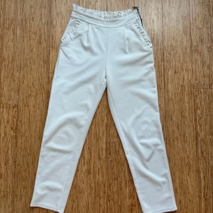 Vita byxor med resårmidja - Snygga vita byxor med resårmidja och rak passform. Perfekta för en avslappnad stil. Byxorna har en enkel design utan mönster och är tillverkade i ett mjukt material.