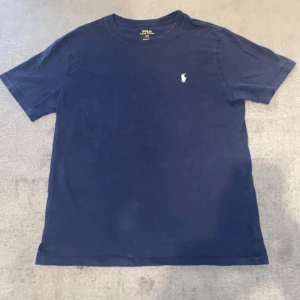 Blå t-shirt från Lyle & Scott - Säljer 3 tshirts för 300kr med deras klassiska logga på bröstet. Perfekt för en avslappnad stil och passar till det mesta. T-shirten är i bomull och har korta ärmar. Polo och Levis=Xs/S. Lyle&Scott= S/M