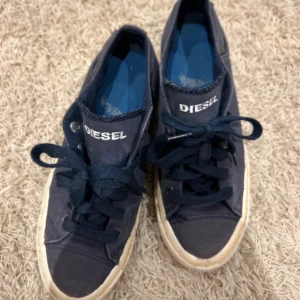 Mörkblå diesel skor - Mörkblåa dieseldjur i jeans material, använda men fortfarande i bra skick i storlek 38.  