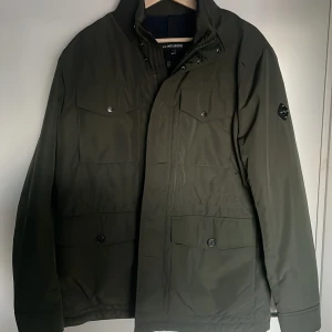 J.Lindeberg Field Jacket - Jag säljer nu min oanvända J.Lindeberg jacka i färgen grön.  Jackan är oanvänd och därför i ny skick. Nypris för jackan är 3500