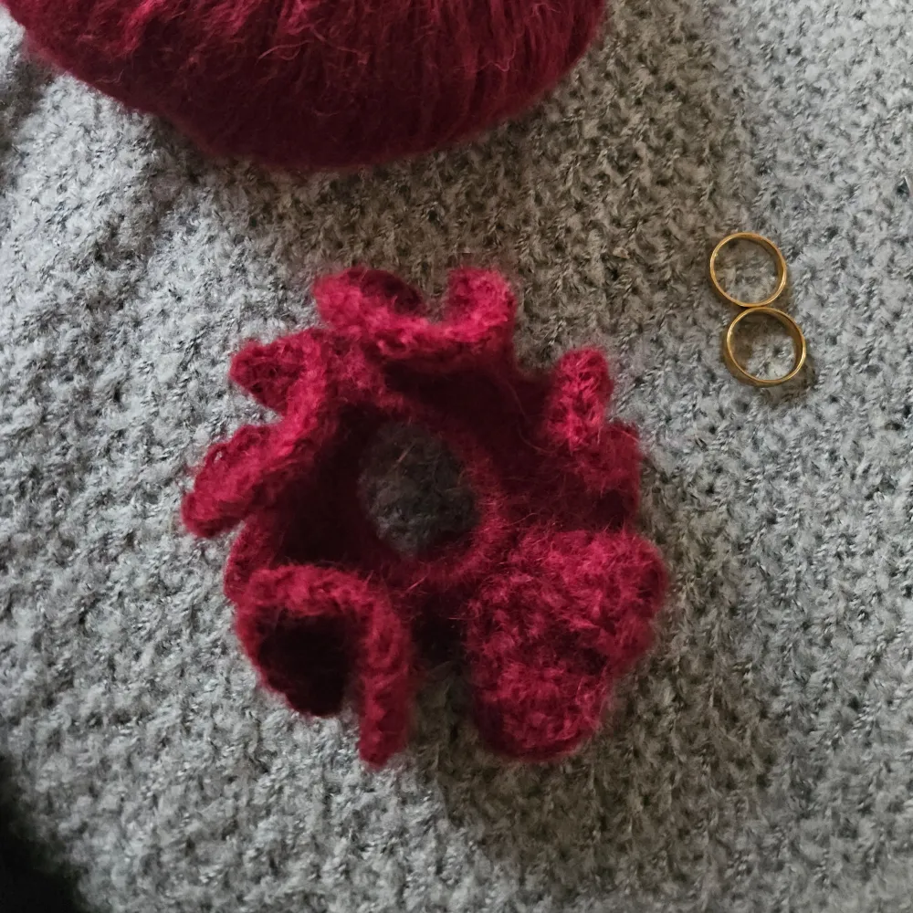 Säljer en superfin vinröd virkad scrunchie som är perfekt för att ge en mysig touch till din outfit. Den är fluffig och mjuk, vilket gör den skonsam mot håret. Perfekt accessoar för höst och vinter!. Accessoarer.