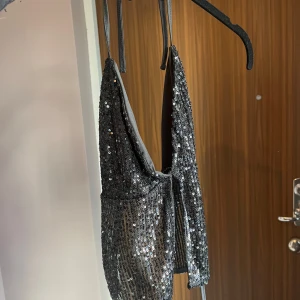 Topp som man knyter vid ryggen, helt öppen på ryggen  - Fin glittertopp. 