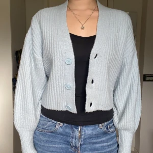 Ljusblå kofta ballongärm - Supermjuk babyblå stickad kofta med vida ballongärmar. Har klippt av lappen men om jag minns rätt köpte jag den på hm! Bra skick, behöver kanske lite noppborttagning men annars fin!