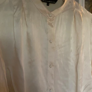 Beige sidenblus - Säljer en elegant beige blus i sidenmaterial. Den har långa ärmar och knappar framtill. Perfekt för en stilren look, oavsett om det är till vardags eller fest. 🕊️
