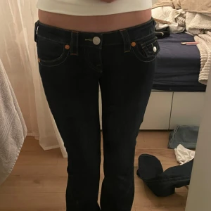 Mörk blåa true religion jeans - Mörk blåa true religion jeans som är köpta på Nelly, i storlek W23, nypris 1300kr Men sydde förut upp dom då de var för långa, så nu är hela benet från grenen 72cm💖färgen på byxorna på bild 4 ser annorlunda ut då jag använde blixt och det var lite annorlunda ljus. Pris går att diskutera