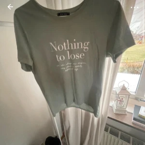 Grön t-shirt från Amisu - Säljer en grön t-shirt från Amisu med texten 'Nothing to lose' tryckt på framsidan. T-shirten har en rund halsringning och korta ärmar. Perfekt för en avslappnad stil. Storlek S. Bilderna är mina egna från Vinted❤️❤️