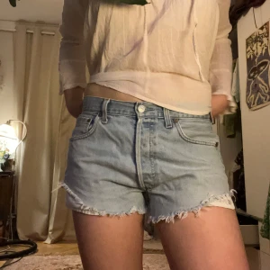 Ljusblå jeansshorts - Snygga ljusblå jeansshorts med fransiga kanter och klassisk femficksdesign. Perfekta för en avslappnad sommarlook. W 32 och L 32.