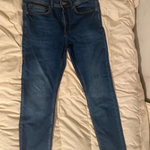 Blå slim fit jeans från Hampton Republic - Snygga blå slim fit jeans från Hampton Republic. De har en klassisk femficksdesign och en bekväm passform. Perfekta för en stilren look.