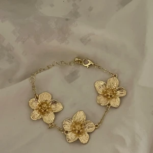 Blommigt armband - Superfint blommigt armband i guld helt nytt och oanvänt, justerbart så passar alla💕likt iouko