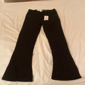 Svarta Skippy Flare jeans från 157 - Snygga svarta flare jeans från 157 i modellen Skippy Flare. Perfekta för en trendig look med sin utsvängda stil. Passar bra till både vardag och speciella tillfällen.