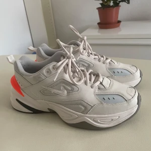 Nike skor - Snygga och bekväma sneakers från Nike i en ljusgrå färg med en iögonfallande orange detalj på hälen. Skorna har snörning och en robust sula som ger bra stöd. Perfekta för en sportig look. Dem är storlek 40 men passar 39, använda 1 gång.