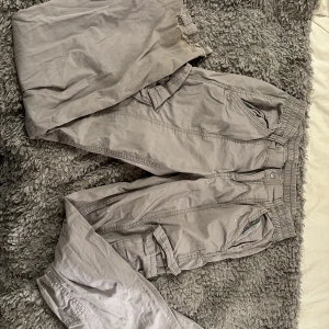Grå cargobyxor från H&M - Säljer ett par grå cargobyxor från H&M i storlek XS. Byxorna har elastisk midja och flera fickor för en praktisk look. Perfekta för en avslappnad stil. Pris kan diskuteras 💕