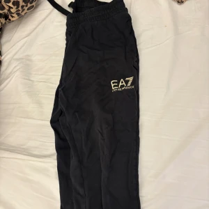 Svarta mjukisbyxor från Emporio Armani - Snygga svarta mjukisbyxor från Emporio Armani med elastisk midja och logotypdetalj på benet. Perfekta för en avslappnad stil.