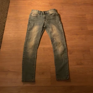 Vintage Denim Day jeans - Snygga vintage jeans från Denim Day i en klassisk blå tvätt. De har en straight passform och är perfekta för en avslappnad stil. Jeansens slitna look ger dem en cool och trendig känsla.