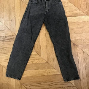 Svarta jeans från Woodbird - Snygga svarta jeans från Woodbird i en klassisk straight fit. Perfekta för en stilren look med en bekväm passform. Dessa jeans är ett måste i garderoben för alla som älskar tidlös stil.