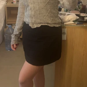 Svart kortkjol - Snygg svart kortkjol som passar perfekt till olika outfits. Kjolen har en enkel och stilren design, vilket gör den lätt att matcha med olika toppar och accessoarer. Den är i linnematerial