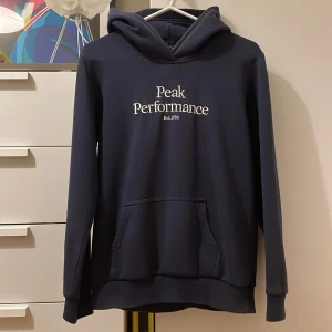 Mörkblå hoodie från Peak Performance - Säljer den här mörkblå hoodien som är använd men i mycket bra skick. Priset kan diskuteras. Hör av dig för fler bilder eller frågor.
