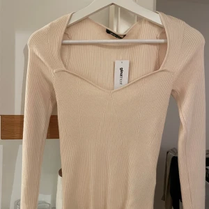 Topp Gina tricot  - Helt ny topp från Gina med hjärtformad urringning i beige färg. 