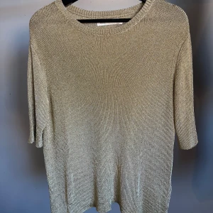 Guldglittrig t-shirt - T-shirt, Carin Wester. Stlk S, oz i storleken och passar även M. Stickad t-shirt i guldglitter, tung i tyget och faller snyggt! Hittar ingenting att anmärka på.