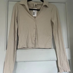 Långärmad topp - Långärmad v-ringad topp från Nelly, aldrig använd prislappen kvar.