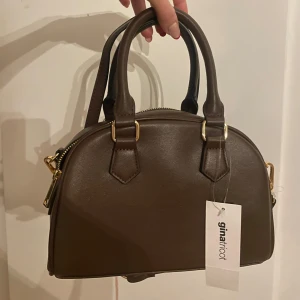 Väska - Säljer denna bruna väska från Gina som är helt oanvänd.