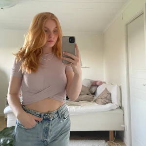 Ljuslila/rosa topp - Ribbad, kort topp med snygg detalj vid naveln. 