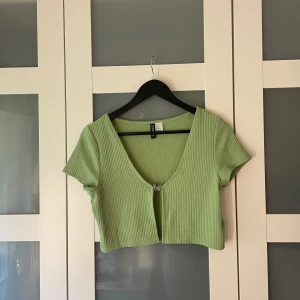 Grön topp med detalj - Grön topp med metall-fjäril fram. Nyskick! 