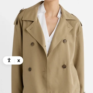 Beige trenchcoat - Säljer en snygg beige trenchcoat med klassisk dubbelknäppning och axelklaffar. Jackan har ett bälte i midjan och är perfekt för vår och höst. Den är stilren och passar både till vardags och fest. frpn stradivarius köpt för 400kr