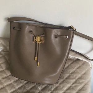 Ralph lauren Bucket bag! - Ralph lauren väska, modell: Lauren Ralph Lauren Väska Andie 19 Drawstring  Nypris 4000kr Använd men i fint skick! Mått: B 24 x H 21 x D 13 cm Äkta läder!