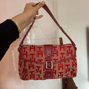 Röd axelväska Tommy Hilfiger - Säljer en superfin röd axelväska från Tommy Hilfiger💓 Fint skick! Perfekt för både vardag och fest!❤️