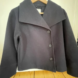 Kappa  - En svarta kappa en blåa undertoner.