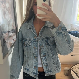 Jeansjacka från Pull&Bear - Säljer en snygg jeansjacka från Pull&Bear med prislappkvar i storlek S. Den har långa ärmar och knappar framtill samt två bröstfickor. Perfekt för vår och höst! Säljer för köpte fel storlek och glömde skicka tillbaks. NY PRIS 450kr