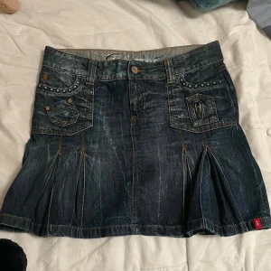 Jeanskjol med nitar - Säljer en supercool jeanskjol med nitar och fickor fram och bak. Kjolen har en snygg tvättad look och är ifrån Myrorna. Den har också dekorativa sömmar och små detaljer som ger den en touch. Har inte kommit till så mycket användning för den passar inte mig :(