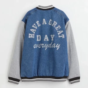 Blå och grå jeansjacka med tryck - Säljer en jeansjacka med grå ärmar. Den är i nyskick och har inga defekter. Kontakta mig om du har fler frågor 😊