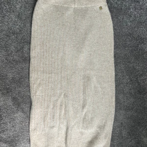 Beige ribbad kjol - Säljer en superfin beige ribbad kjol som är perfekt för både vardag och fest. Kjolen har en tight passform och är gjord i ett mjukt och stretchigt material. Den är midilång och har en stilren design som gör den lätt att matcha med olika toppar och skor. Perfekt för höst och vår!