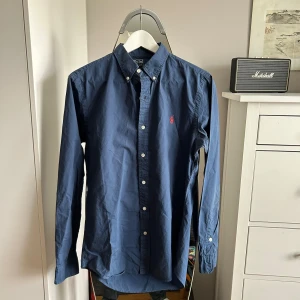 Mörkblå Ralph Lauren Skjorta - Mörkblå Polo Ralph Lauren skjorta i felfritt skick! Slim fit. Nypris runt 1700kr.