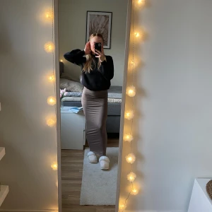 Beige långkjol - Säljer en superfin beige/brun långkjol som är perfekt för både vardag och fest. Kjolen har en tight passform som framhäver figuren och är gjord i ett mjukt och bekvämt material🩷
