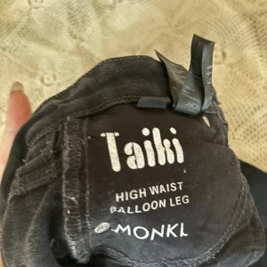 Svarta byxor från Monki - Säljer ett par svarta byxor från Monki i modellen Taiki. De är högmidjade med en ballongformad passform som ger en cool och avslappnad look. Perfekta för både vardag och fest!