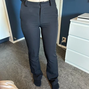 Svarta byxor från BikBok - Säljer ett par svarta byxor från BikBok i storlek 34. De är högmidjade och har en slim passform med dragkedja och knapp framtill. Perfekta för både vardag och fest!