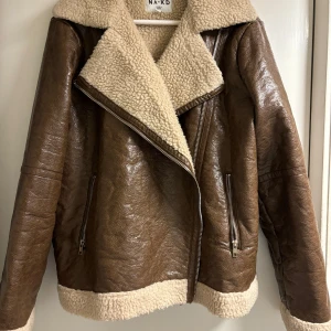 Biker jacka NA-KD  - Brun bikerjacka från NA-KD i strl 36 men passar en 38 också.   Använd en halv vintersäsong, fortfarande fräsch och utan synligt slitage. 