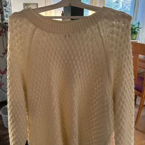 Vit stickad tröja från H&M - Säljer en superfin vit stickad tröja från H&M. Den är perfekt för kyliga dagar med sitt mysiga och varma material. Tröjan har ett snyggt stickat mönster och långa ärmar. Passar perfekt till både vardag och fest!💕❄️