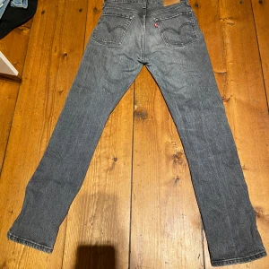 Grå Levis 501 jeans - Säljer ett par klassiska grå Levis 501 jeans. De har en straight passform och är tillverkade i slitstarkt denim. Perfekta för både vardag och fest! Storlek w27 L30
