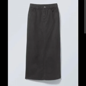 Svart långkjol i jeansmaterial - Säljer en stilren svart långkjol i jeansmaterial. Kjolen har en klassisk design med knapp och dragkedja framtill. Perfekt för både vardag och festliga tillfällen. Passar till allt och är superbekväm!