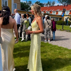 Gul balklänning med slits och knytning i ryggen - Supersnygg gul balklänning. Tajt passform med slits, lite spets med glitterstenar samt snygg knytning i ryggen